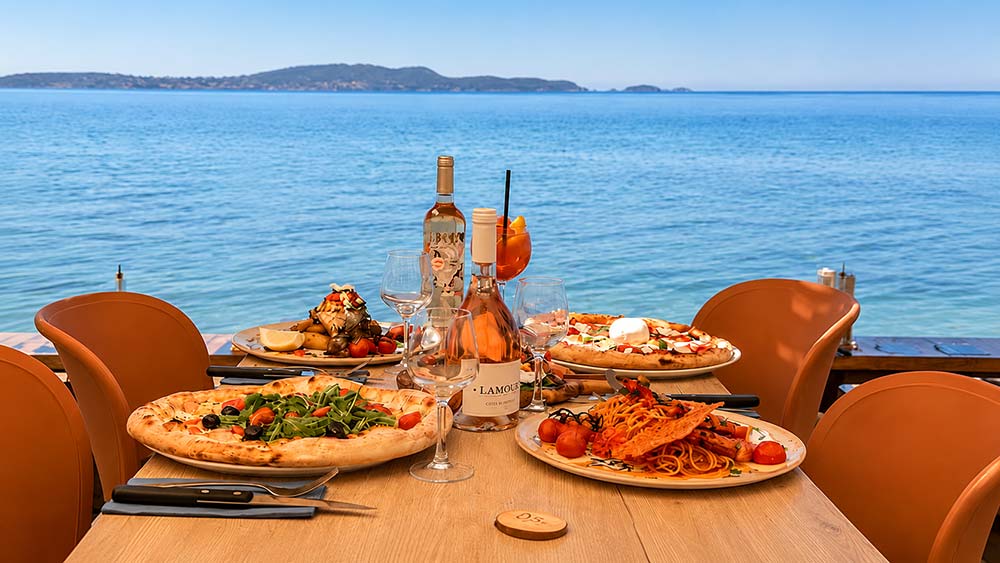 Table vue mer au restaurant Gaetano Plage sur la plage de l'Almanarre à Hyères avec pizzas et rosé