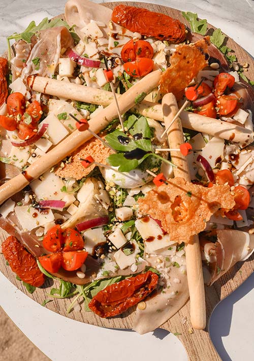 Entrée italienne généreuse avec salade, gressins, tomates séchées et mozzarella au restaurant Gaetano Plage l'Almanarre à Hyères