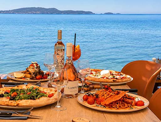Table vue mer au restaurant Gaetano Plage sur la plage de l'Almanarre à Hyères avec pizzas et rosé
