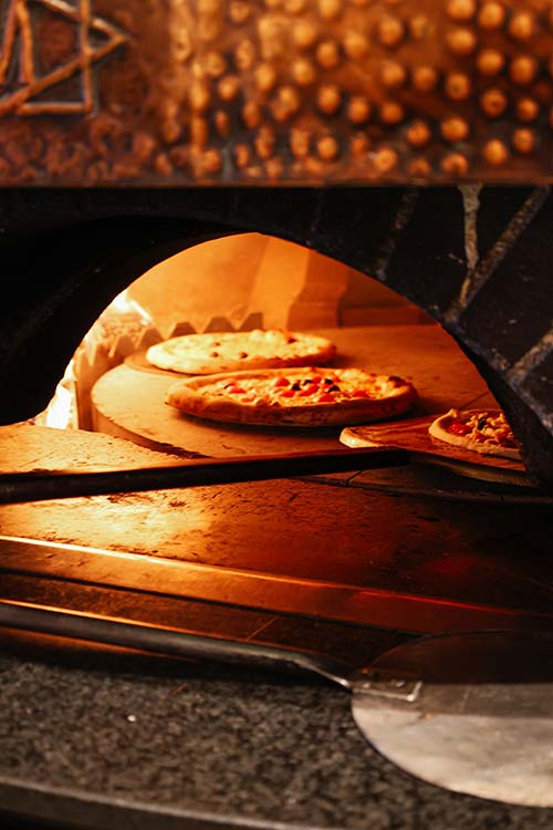Pizzas artisanales en cuisson dans le four à bois de la Pizzeria Gaetano au port de Toulon